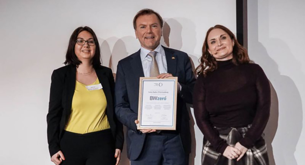Lotto BW-Geschäftsführer Paul Nemeth freut sich zusammen mit Britta Groß (links), Nachhaltigkeitsbeauftragte bei Lotto BW, über die Auszeichnung BWzero. Julia Kovar, Leiterin der Klimaschutzstiftung BW, überreichte die Urkunde.